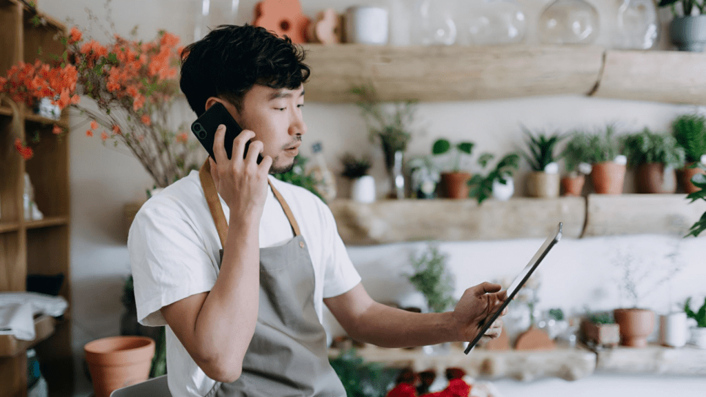 Young businessman talking on a cordless phone to customer.