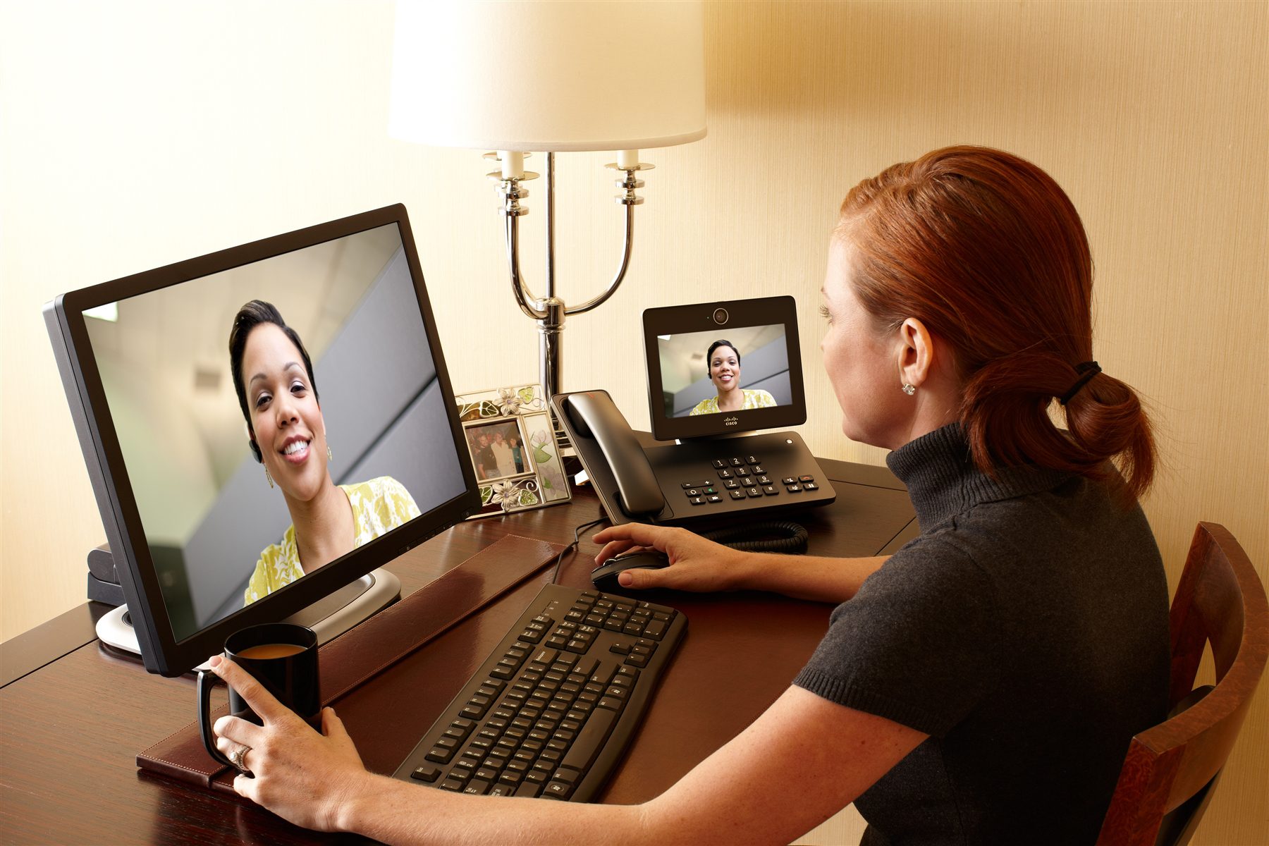 Two business women video conferencing remotely